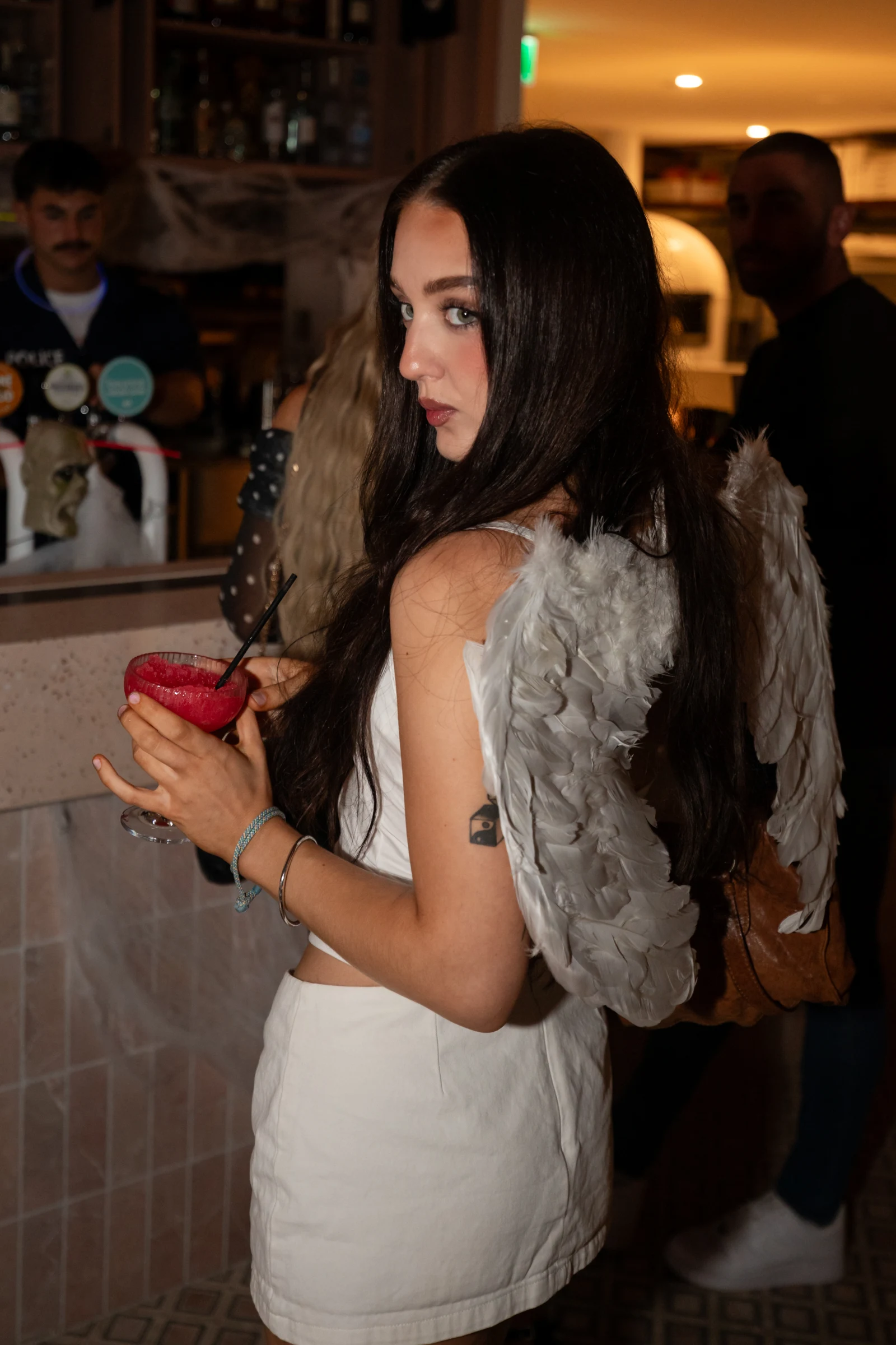 Halloween guest wearing feathered angel wings at the Bounce Surfers bar